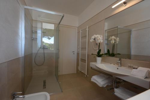 y baño con ducha, lavabo y espejo. en Residence La Villa, en Tortoreto Lido