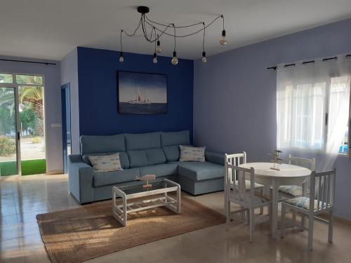 Apartamentos Venta Lanuza, El Campello في إل كامبيلو: غرفة معيشة زرقاء مع أريكة وطاولة