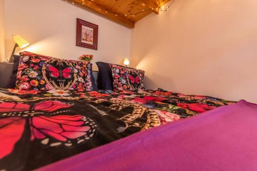 Un dormitorio con una cama grande con mantas y almohadas de colores. en K5 - The happy home in the Nightlife Zone, en Budapest