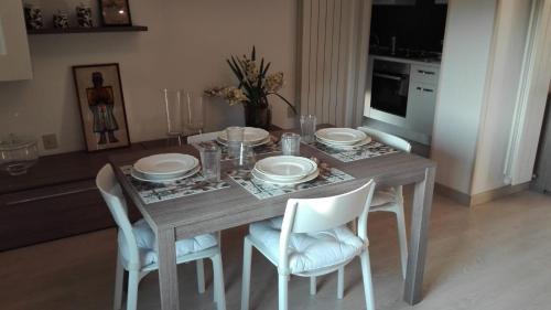 a dining room table with white plates and chairs at Ca' dei Mille in Iseo