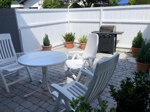 a patio with a table and chairs and a grill at Sonnenhaus in Sindelfingen