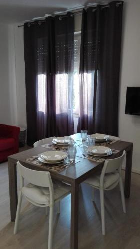 a dining room table with two chairs and a table with dishes at Ca' dei Mille in Iseo