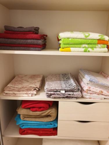 a closet with colorful towels and folded towels at Грибовка,Морской Аромат in Gribovka
