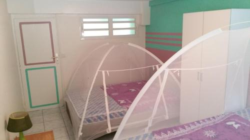 a childs bedroom with a bed with a canopy at PERLE CRÉOLE in Sainte-Anne