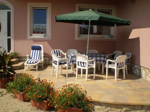 a patio with a table and chairs and an umbrella at Károlyi Panzió in Eger