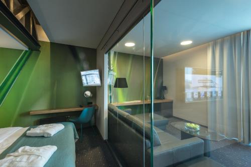 a hotel room with a bed and a glass wall at Regatta Hotel Restauracja Spa in Poznań