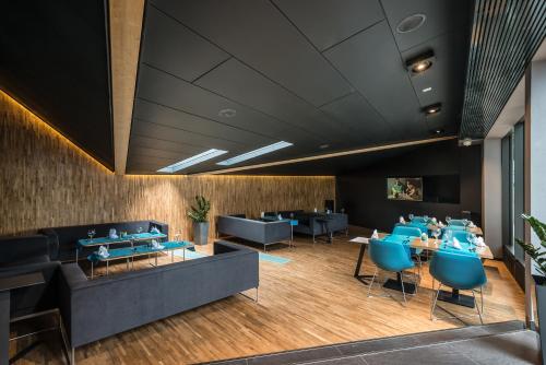 a dining room with blue chairs and tables at Regatta Hotel Restauracja Spa in Poznań