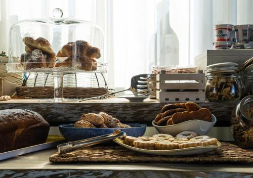 a table with various types of bread and pastries at Kepos Etna Relais & Exclusive Spa in Santa Venerina