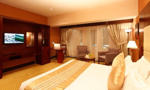 a hotel room with a bed and a flat screen tv at Almsakn Alola Hotel Company in Riyadh