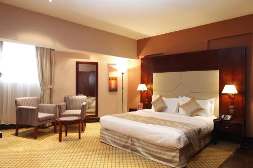 Habitación de hotel con 1 cama y 2 sillas en Haven Plaza en Riad