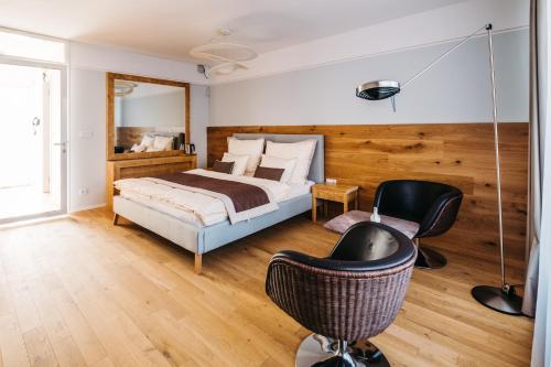 a bedroom with a bed and two chairs at Boutique hotel Corso in Řevnice