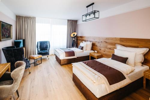 a hotel room with two beds and a desk at Boutique hotel Corso in Řevnice