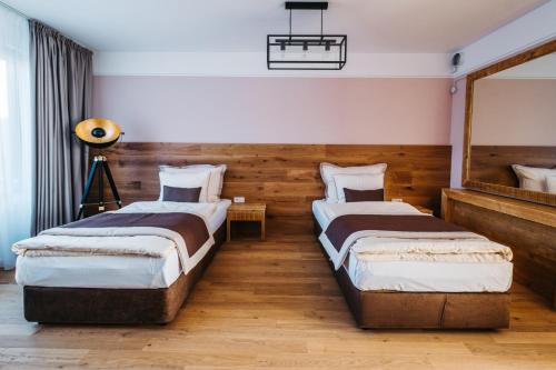 a bedroom with two beds and a mirror at Boutique hotel Corso in Řevnice