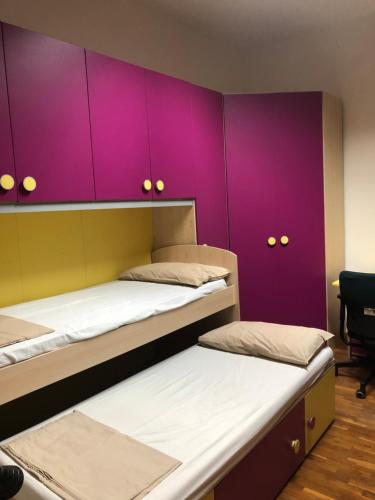ポッツオーリにあるCasa Di Liaの紫色のキャビネット付きの部屋のベッド2台