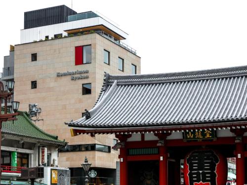a building with a chinese roof in a city at Kaminarimon Ryokan in Tokyo