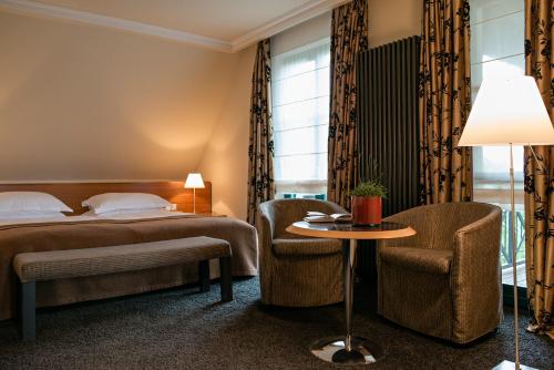 a hotel room with a bed and a table and chairs at Zeller-Hotel+Restaurant in Kahl am Main