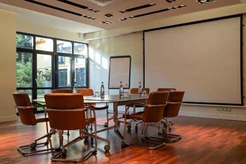 a conference room with a table and chairs and a large screen at Zeller-Hotel+Restaurant in Kahl am Main
