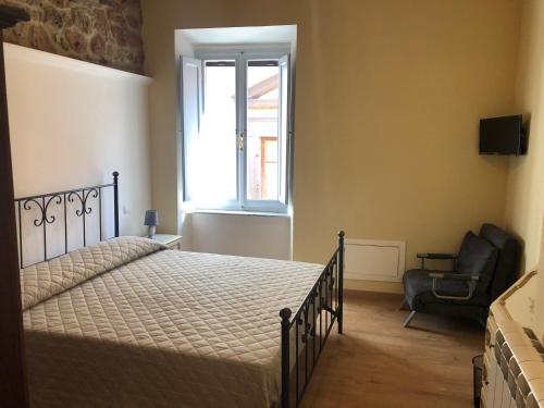 a bedroom with a bed and a chair and a window at Alloggi per uso turistico A&M in Acquapendente