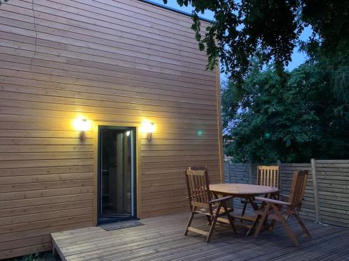 une table et des chaises en bois sur une terrasse en bois dans l'établissement Cube Nature, à Bitche