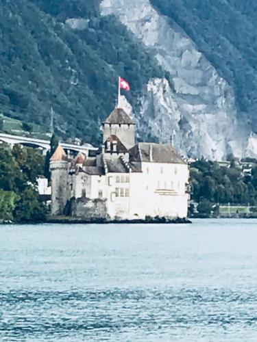 a castle in the middle of a body of water at Rue de Bel-Aube Chalet Joli 10 in Crans-Montana