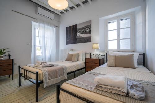 Duas camas num quarto com paredes brancas e janelas em Plakoto House em Exámbela