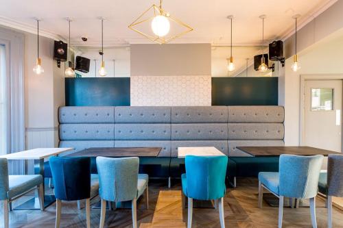 a dining room with blue chairs and a table at Bawn Lodge in Chester