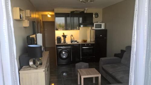 Cet appartement comprend une petite cuisine et un salon. dans l'établissement Heliopolis Village Naturiste, au Cap d'Agde