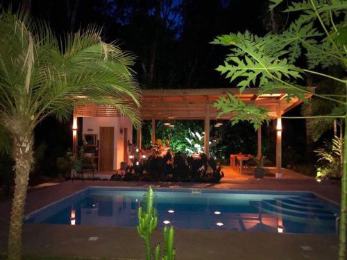 a swimming pool in front of a house at night at La Paz del Caribe Adults Only in Puerto Viejo