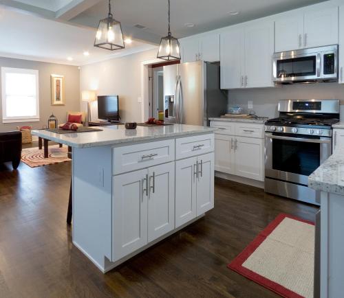 a kitchen with white cabinets and a large island at Modern Bungalow Near Downtown in Atlanta