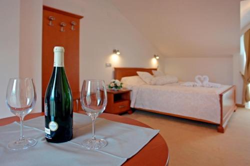 uma garrafa de vinho sentada numa mesa com dois copos de vinho em Hotel Garden em Ohrid