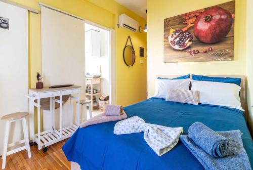 a bedroom with a blue bed and a painting of an apple at Central 6th Floor Studio Near Metro & View&200mbps in Athens