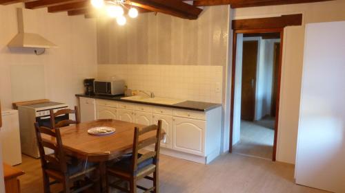 a kitchen with a wooden table and a kitchen with a sink at La Maison de Ners in Pertheville-Ners