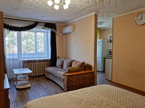 Il comprend un salon avec un canapé et une cuisine. dans l'établissement Lux Apartment on Potanina 19, à Öskemen