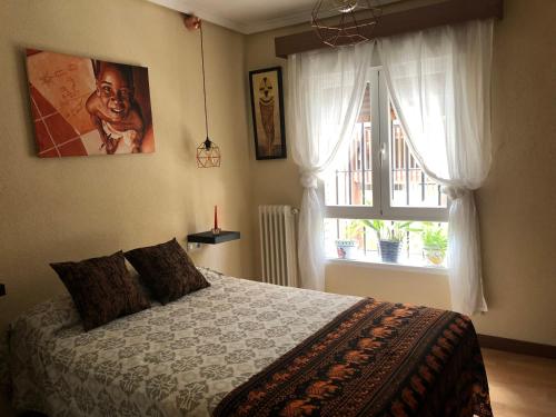 um quarto com uma cama grande e uma janela em Apartamento Entero al lado de calle de Alcalá em Madrid