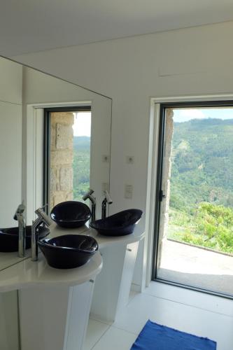 La salle de bains est pourvue de 2 lavabos et d'une grande fenêtre. dans l'établissement Quinta do Sol, à Castelo de Paiva