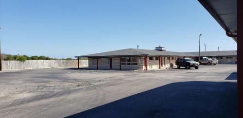 um edifício com um parque de estacionamento em frente em Executive Inn em Corpus Christi