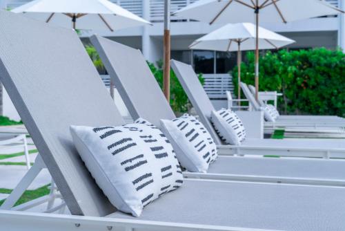 a row of white lounge chairs with umbrellas at Mullins Grove in Saint Peter