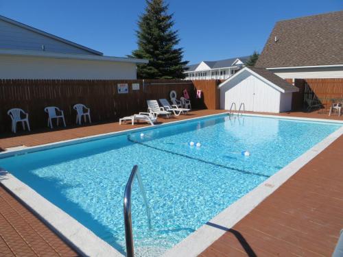 a large swimming pool with blue water in a yard at Bridgeview Motel in Mackinaw City