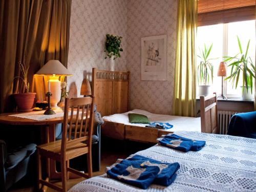 sypialnia z 2 łóżkami, stołem i biurkiem w obiekcie Eklanda Bed & Breakfast w Göteborgu