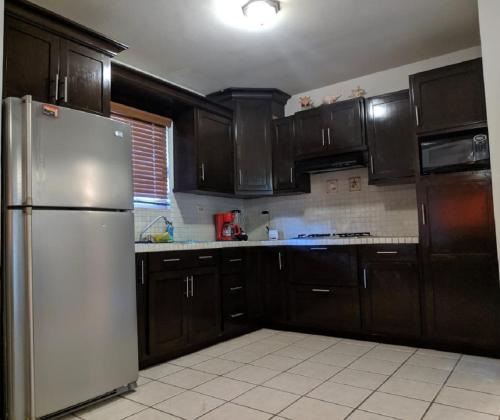a kitchen with wooden cabinets and a stainless steel refrigerator at Casa Villa Serena 4 in San Carlos