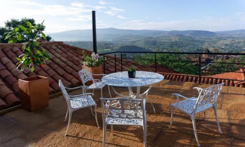 a table and chairs on a balcony with a view at Tocagua in Barichara