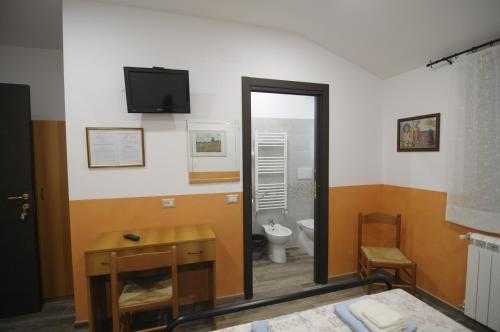 La salle de bains est pourvue de toilettes et d'une télévision murale. dans l'établissement Azienda Agrituristica Pericle, à Montella