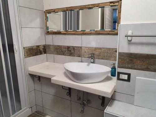 a bathroom with a white sink and a mirror at B&B città del carrubo in Rosolini