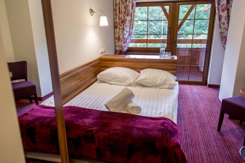 a large bed in a room with a window at Leśne Patio in Katowice
