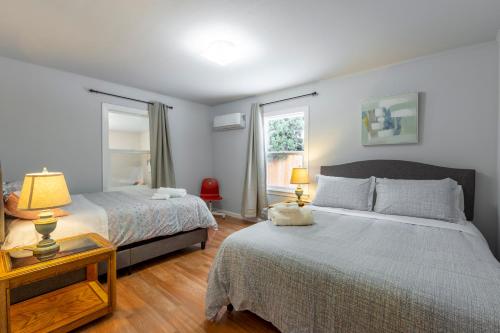 1 dormitorio con 2 camas y 1 mesa con 2 lámparas en @ Marbella Lane 5BR House in Downtown Redwood City, en Redwood City