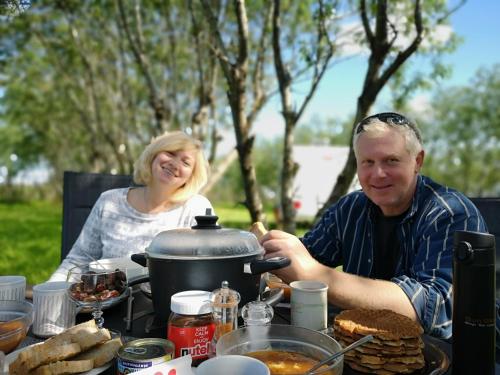 Ein Mann und eine Frau sitzen an einem Tisch mit Essen in der Unterkunft Iceland Igloo Village in Hella