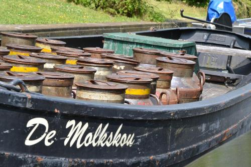 a small black boat filled with pots and pans at Stadsherberg 'Het Wapen van IJlst' in IJlst
