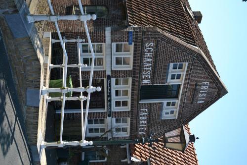 an external view of a brick building with white windows at Stadsherberg 'Het Wapen van IJlst' in IJlst