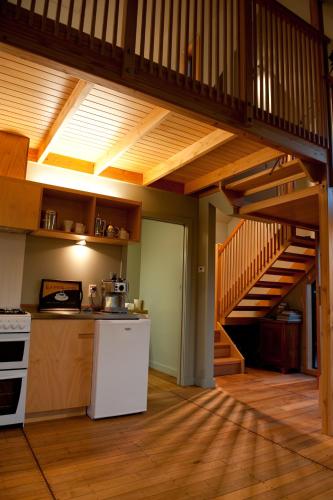 a kitchen with a staircase in a house at Hereweka Garden Retreat in Dunedin