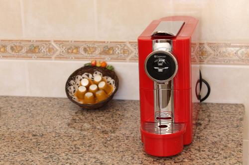 a red blender sitting on a counter next to a bowl of fruit at Casinha dos Avós in Lagos